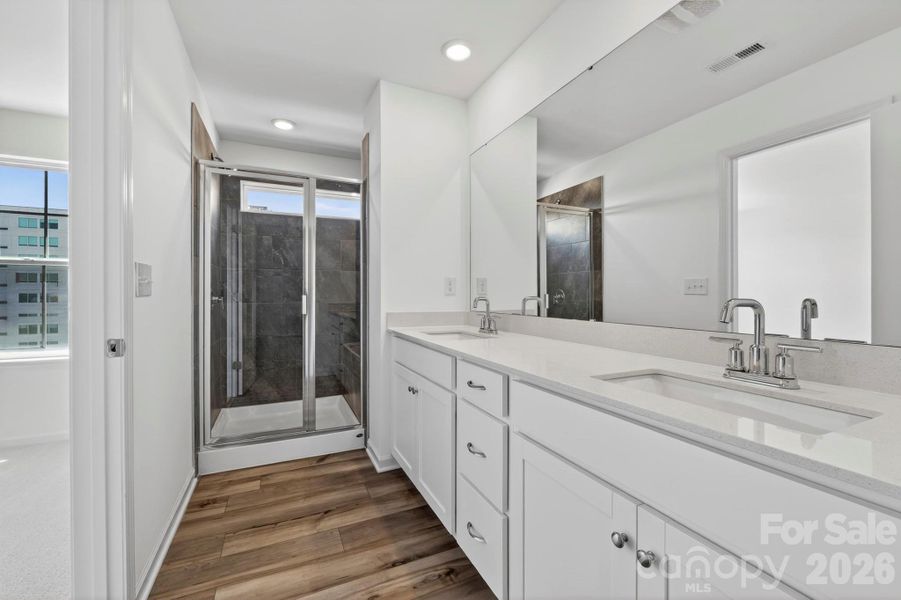 Owners elegant ensuite bath with tiled shower and bench seat