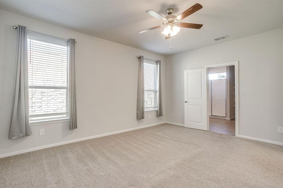 Empty room featuring light colored carpet and ceiling fan