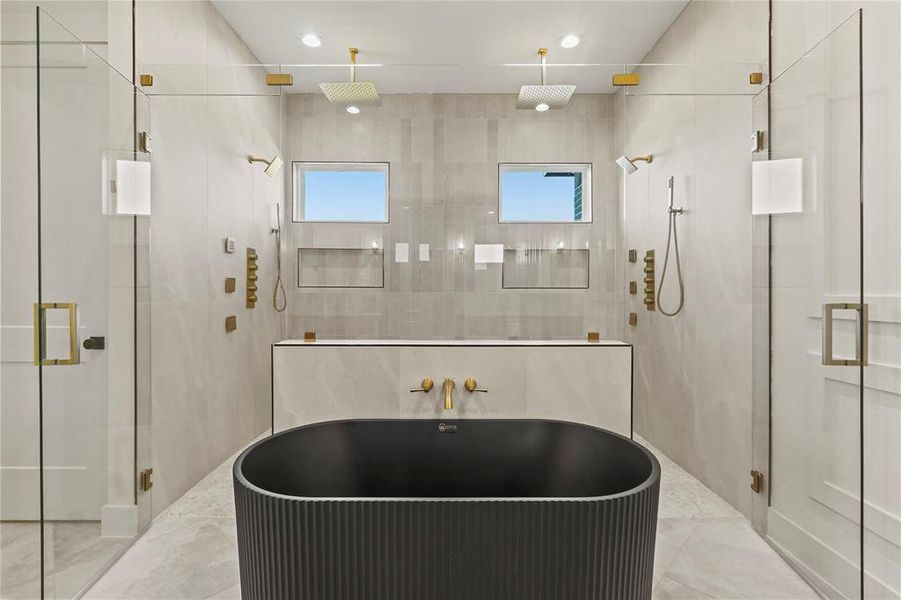 Full bathroom featuring tile walls, a shower stall, a freestanding bath, and recessed lighting Full bathroom featuring tile walls, a shower stall, a freestanding bath, and recessed lighting
