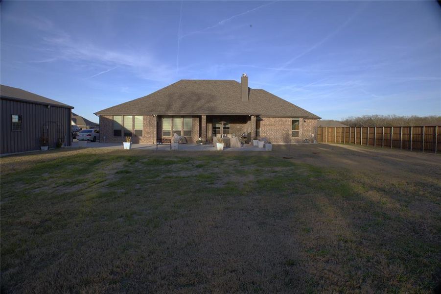 New Addition - Rear view of property featuring brick siding, a patio, a chimney, and a fenced backyard