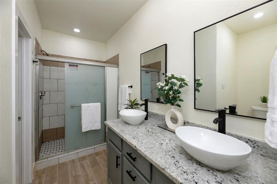 Primary Bathroom with decorative double vanity, a separate walk-in shower, wood tiled floors, and recessed lighting