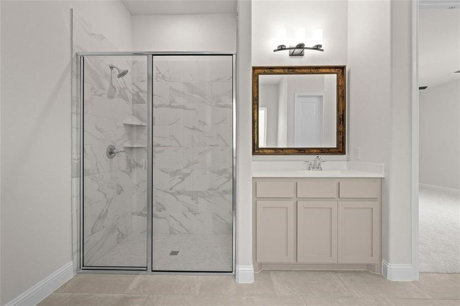 Bathroom with walk in shower, vanity, and tile patterned floors