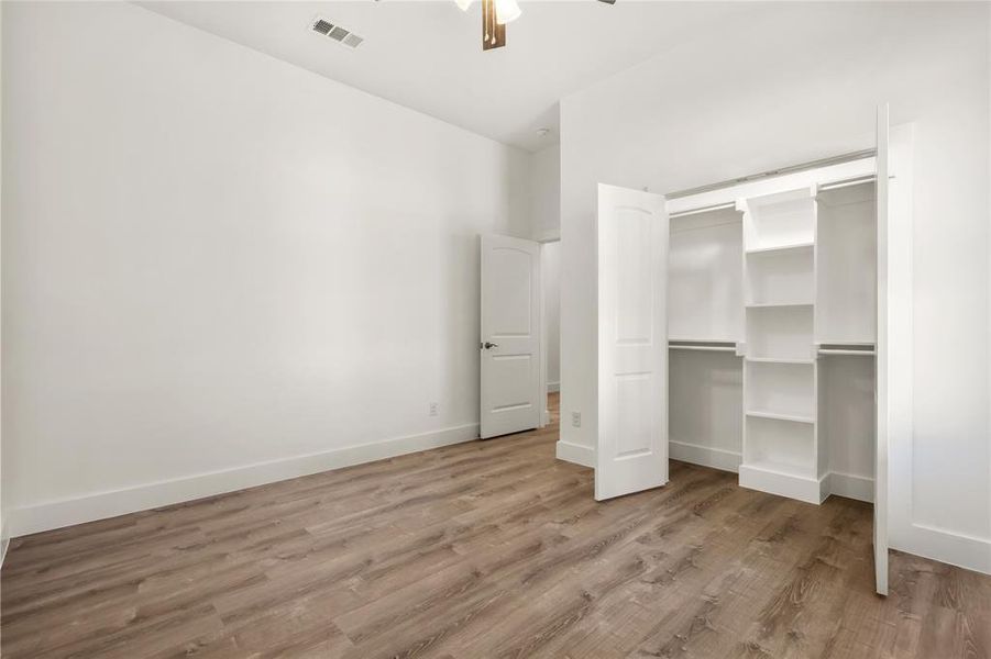 Unfurnished bedroom with ceiling fan and light hardwood / wood-style floors