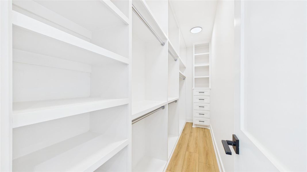 Primary walk-in closet with ample shelving and hanging space. Primary walk-in closet with ample shelving and hanging space.