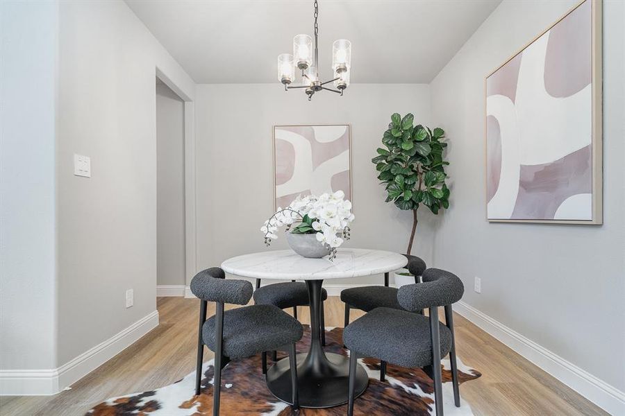 Dining area with a notable chandelier and light hardwood / wood-style floors