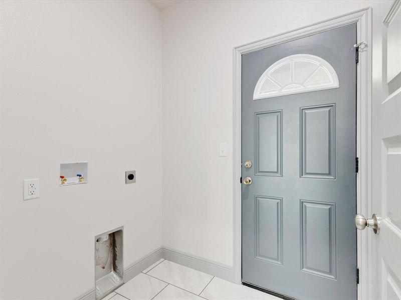 Washroom with light tile patterned floors, hookup for a washing machine, and electric dryer hookup