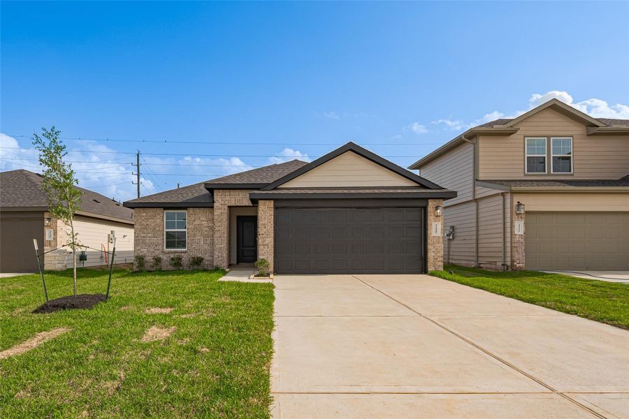 A wide, extended driveway leads to the two-car garage with striking dark-paneled doors that echo the home’s front entry. The brick and light-toned facade is complemented by a manicured lawn that adds a fresh burst of greenery to the curb appeal. A wide, extended driveway leads to the two-car garage with striking dark-paneled doors that echo the home’s front entry. The brick and light-toned facade is complemented by a manicured lawn that adds a fresh burst of greenery to the curb appeal.