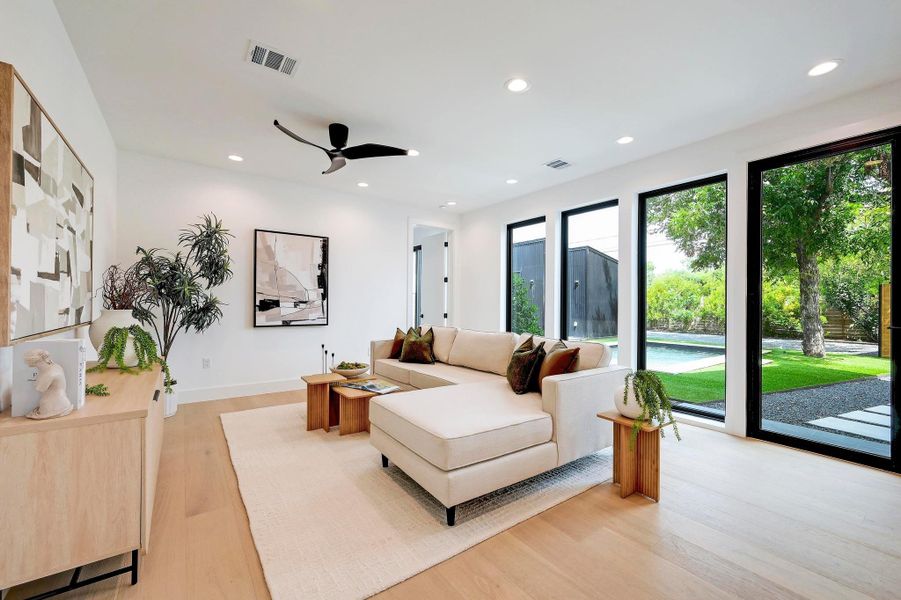 Living room featuring light wood-type flooring, recessed lighting, and a ceiling fan
