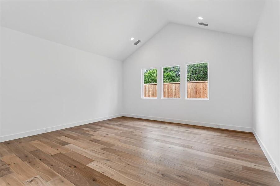 1st floor primary bedroom with pitched ceiling elevates the space