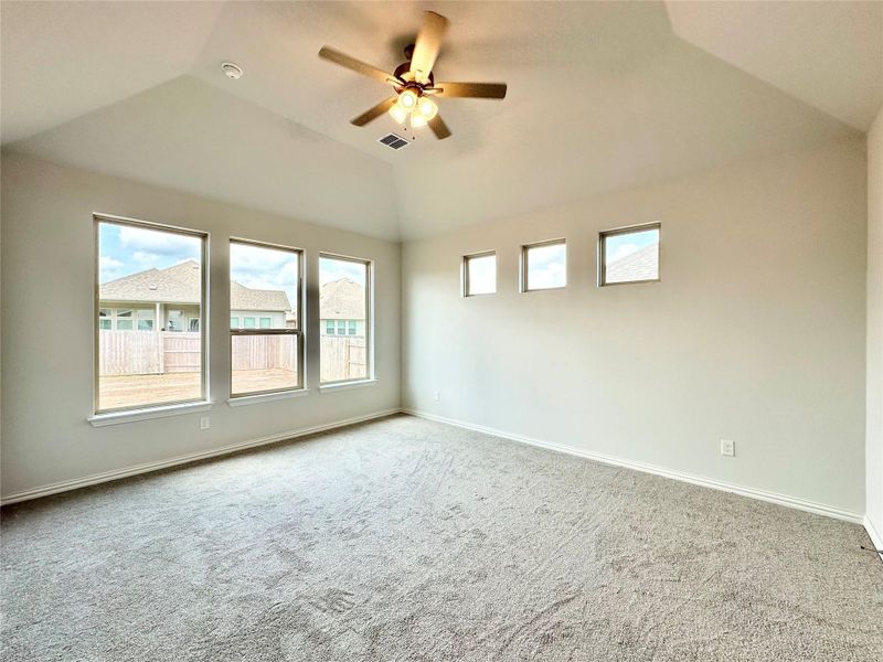 Carpeted spare room with vaulted ceiling and ceiling fan Carpeted spare room with vaulted ceiling and ceiling fan