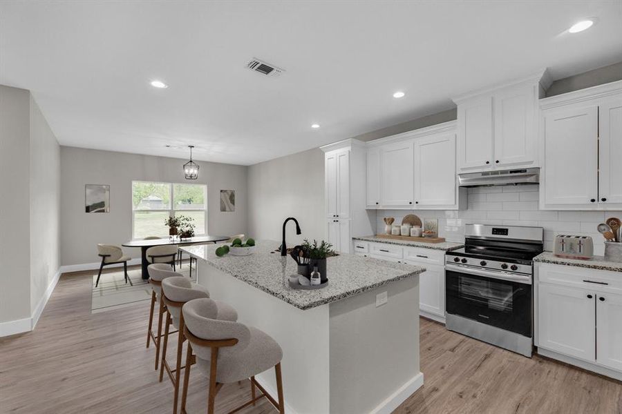 Kitchen with electric stove, decorative backsplash, recessed lighting, light stone counters, and white cabinets