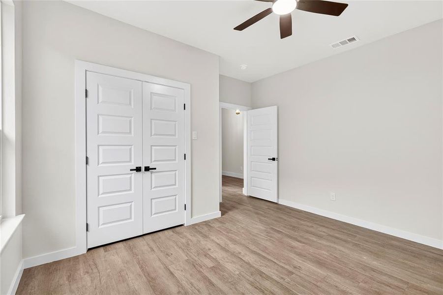 Interior room featuring wood-finish flooring, white baseboards, and light neutral wall finishes