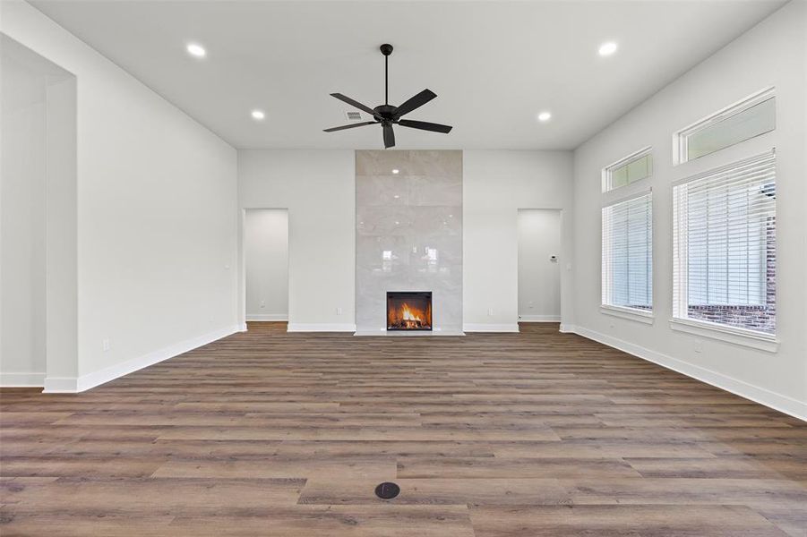 Unfurnished living room featuring recessed lighting, a fireplace, wood finished floors, and a ceiling fan Unfurnished living room featuring recessed lighting, a fireplace, wood finished floors, and a ceiling fan