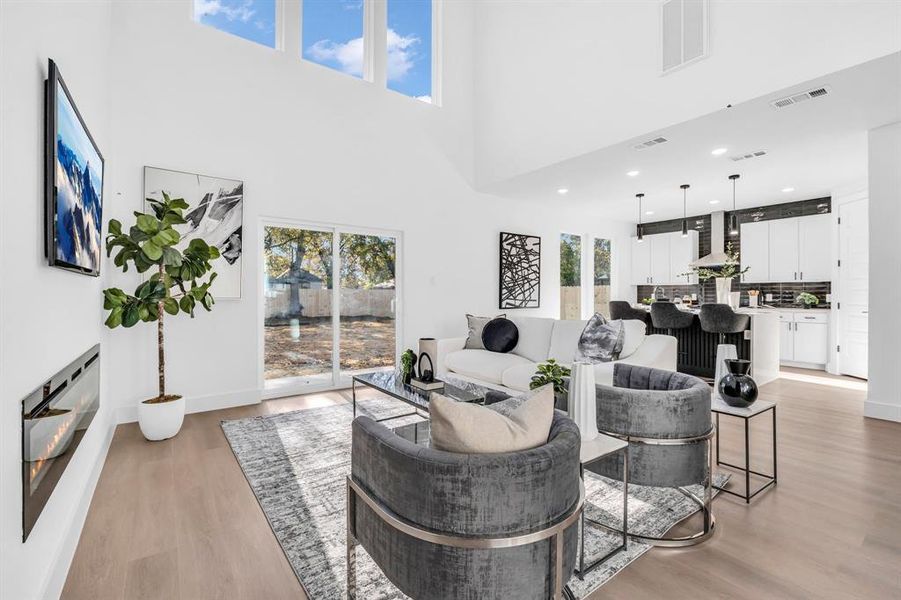 Living room featuring light hardwood / wood-style floors and a towering ceiling