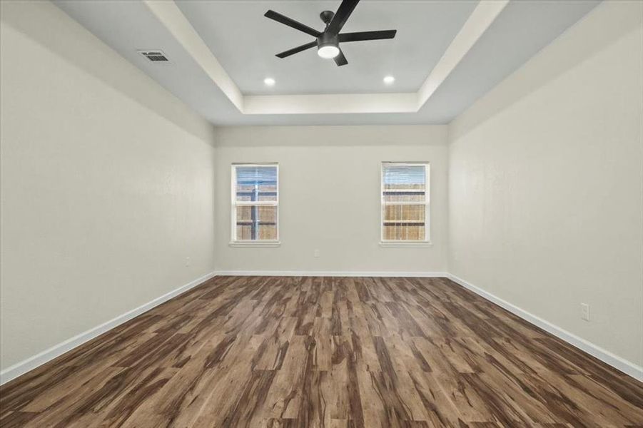 Spare room with dark wood-style floors, a raised ceiling, recessed lighting, and ceiling fan Spare room with dark wood-style floors, a raised ceiling, recessed lighting, and ceiling fan