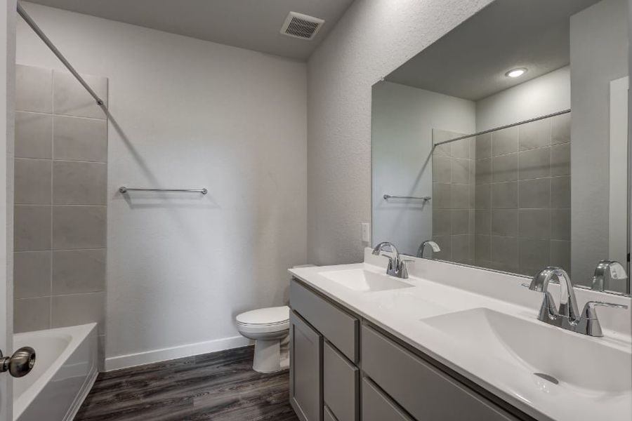 A bathroom with a tub sink and toilet. A bathroom with a tub sink and toilet.