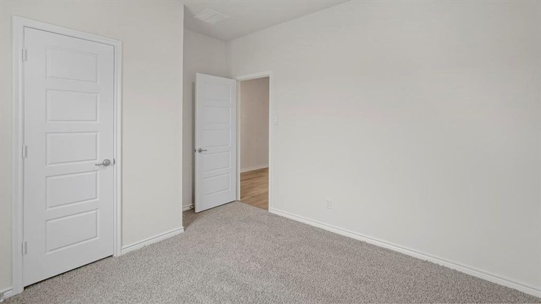Neutral gray carpeting with light gray walls and white trim