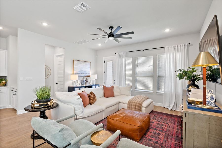 Living room featuring light wood-style flooring, a ceiling fan, and recessed lighting