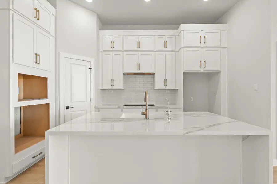 **REPRESENTATIVE PHOTO** The open white kitchen exudes a sense of airy elegance, with pristine cabinets and countertops gleaming under the soft glow of recessed lighting. **REPRESENTATIVE PHOTO** The open white kitchen exudes a sense of airy elegance, with pristine cabinets and countertops gleaming under the soft glow of recessed lighting.