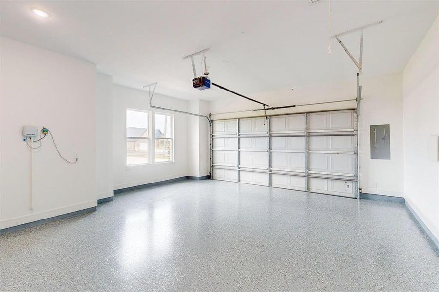 Garage featuring a garage door opener and electric panel