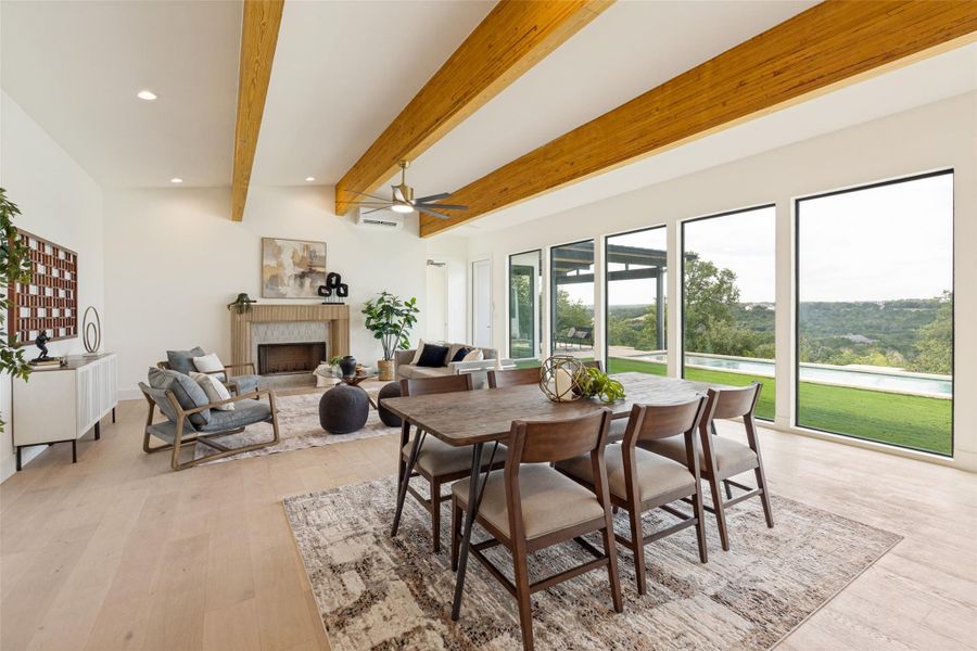 Exposed wood beams frame a captivating kitchen and living area, offering expansive views through a wall of windows.