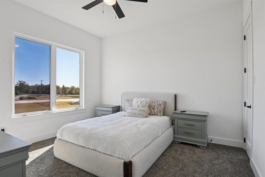 Bedroom featuring dark carpet and a ceiling fan Bedroom featuring dark carpet and a ceiling fan