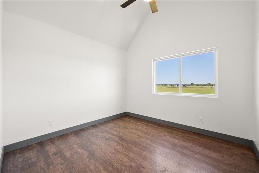 Unfurnished room with dark wood finished floors, high vaulted ceiling, baseboards, and a ceiling fan Unfurnished room with dark wood finished floors, high vaulted ceiling, baseboards, and a ceiling fan