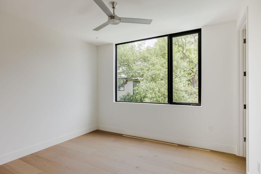 Spare room featuring light wood finished floors and ceiling fan Spare room featuring light wood finished floors and ceiling fan