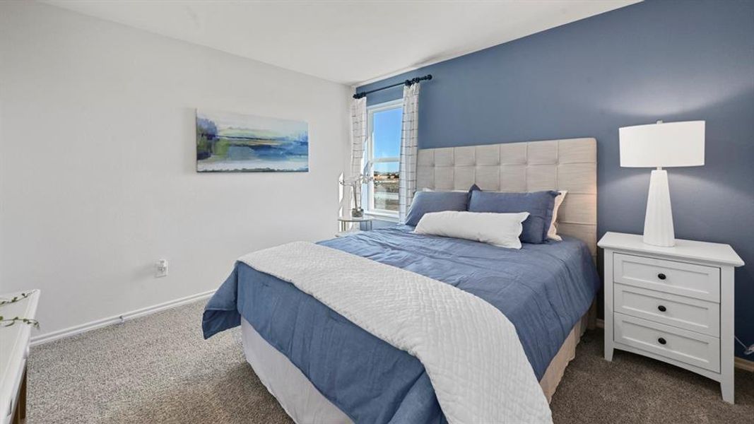 Bedroom featuring dark colored carpet and baseboards