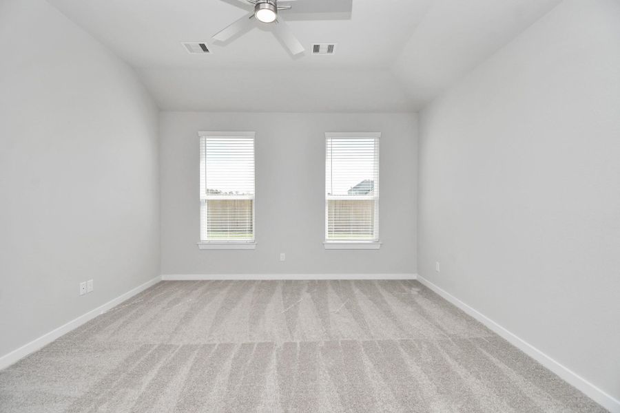 Escape to tranquility in this spacious primary room, adorned with plush carpeting and bathed in the soothing hues of warm paint colors, creating a cozy retreat for relaxation. Sample photo of completed home with similar floor plan. Actual colors and selections may vary. Escape to tranquility in this spacious primary room, adorned with plush carpeting and bathed in the soothing hues of warm paint colors, creating a cozy retreat for relaxation. Sample photo of completed home with similar floor plan. Actual colors and selections may vary.