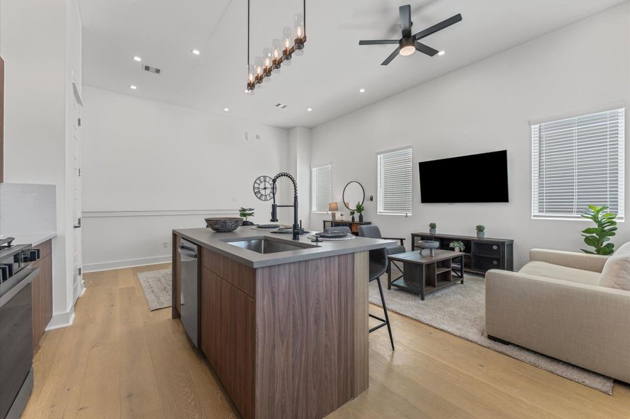 The heart of the second-floor open-concept living, dining, and kitchen, this spacious kitchen island features sleek modern finishes, including a one-sided cascade quartz countertop, a farmhouse sink, and stylish pendant lighting, with a built-in seating area perfect for casual breakfasts or chatting with family and friends.