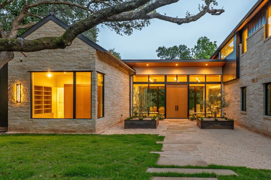 A striking contemporary residence featuring a stone facade and floor-to-ceiling windows. A striking contemporary residence featuring a stone facade and floor-to-ceiling windows.