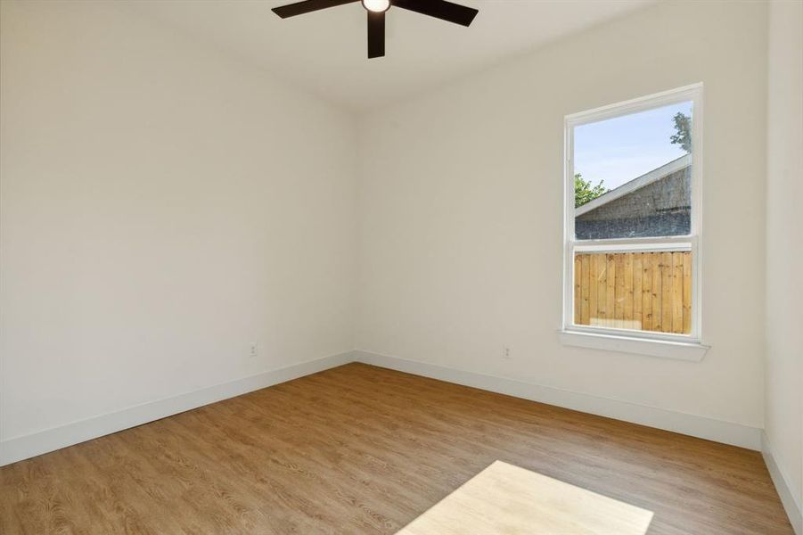 Empty room with ceiling fan and light hardwood / wood-style flooring