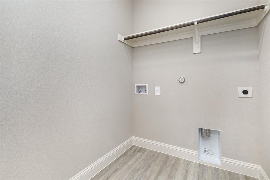 Washroom featuring hookup for a gas dryer, washer hookup, light wood-type flooring, and electric dryer hookup