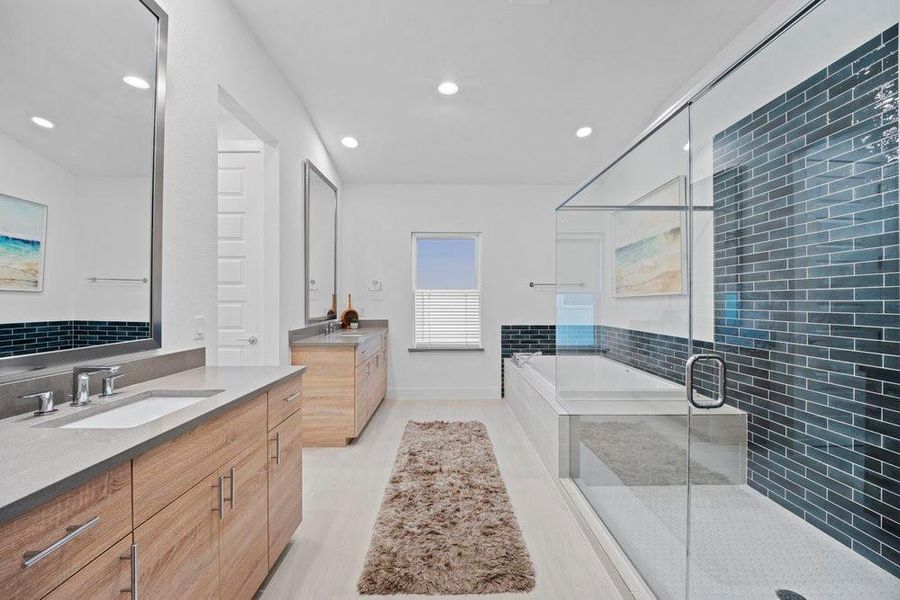 Full bath with a garden tub, a shower stall, two vanities, and recessed lighting
