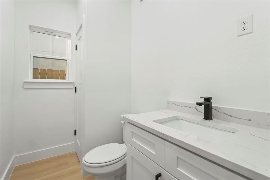 Half bath featuring vanity and light wood finished floors Half bath featuring vanity and light wood finished floors