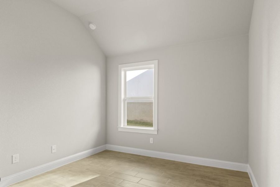 Image of a one story home bedroom with light wood-like flooring and light grey painted walls with a window in the corner Image of a one story home bedroom with light wood-like flooring and light grey painted walls with a window in the corner