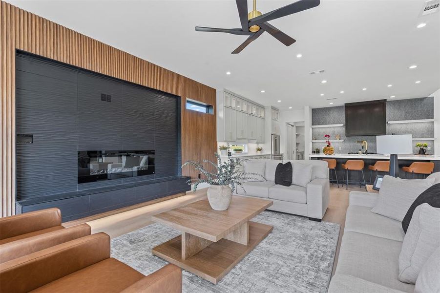 Living area featuring a ceiling fan, light wood-style floors, and recessed lighting