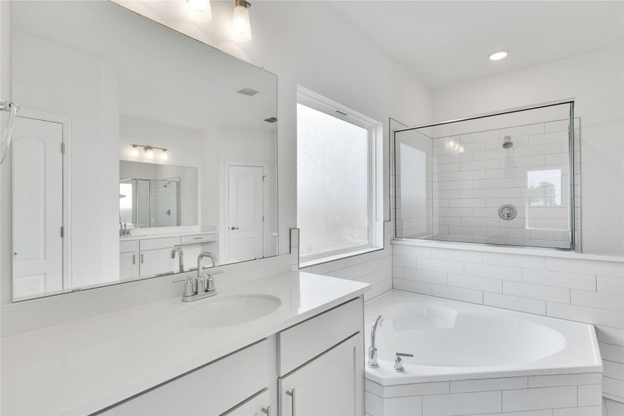 Bathroom with a shower stall, vanity, a bath, and recessed lighting Bathroom with a shower stall, vanity, a bath, and recessed lighting