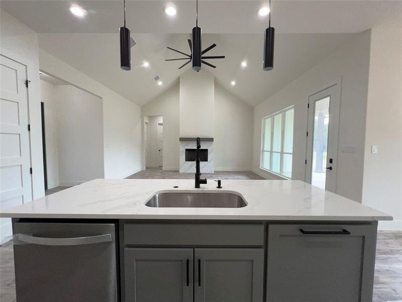 Kitchen island featuring a stainless steel sink, black faucet, and light-toned countertop