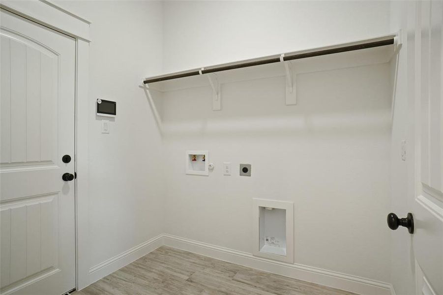 Laundry room with gas dryer hookup, light hardwood / wood-style floors, hookup for a washing machine, and hookup for an electric dryer