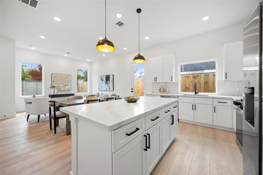 The quartz countertop kitchen island is perfect for conversation or that much needed space to lay out your party spread for everyone to enjoy! The modern pendant lighting adds charm to this space! The quartz countertop kitchen island is perfect for conversation or that much needed space to lay out your party spread for everyone to enjoy! The modern pendant lighting adds charm to this space!