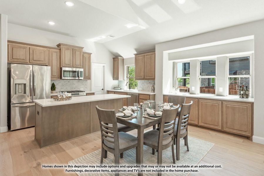 Open kitchen and dining area with tan wood cabinets, center island, stainless appliances, and hardwood floors Open kitchen and dining area with tan wood cabinets, center island, stainless appliances, and hardwood floors