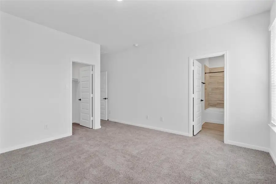 Additional view from primary suite looking towards walk-in closet and ensuite primary bathroom. Additional view from primary suite looking towards walk-in closet and ensuite primary bathroom.