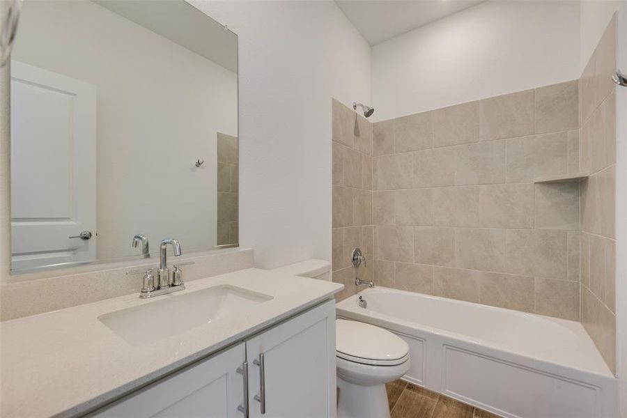 Full bathroom featuring wood-type flooring, vanity, toilet, and tiled shower / bath