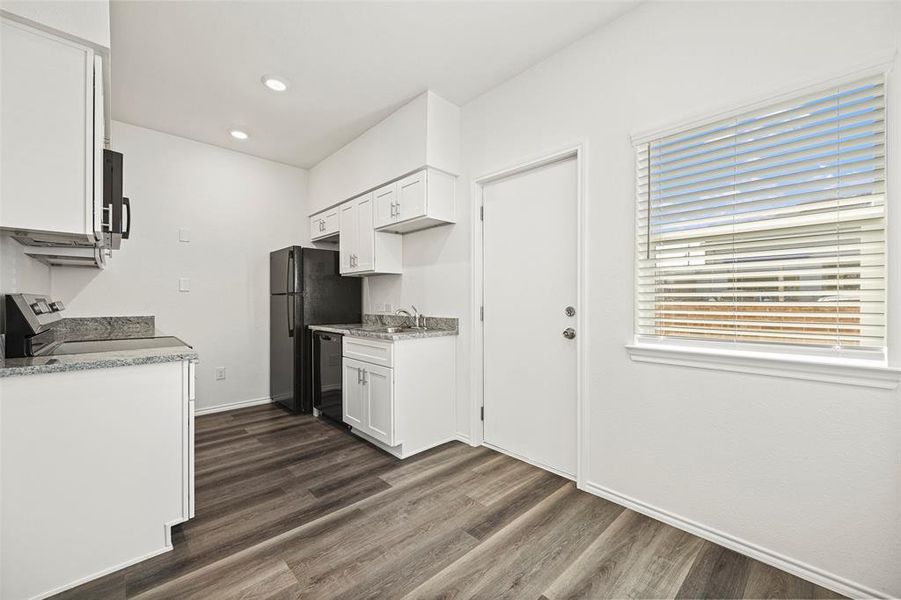 Kitchen featuring white cabinets, dark hardwood / wood-style flooring, sink, and black appliances