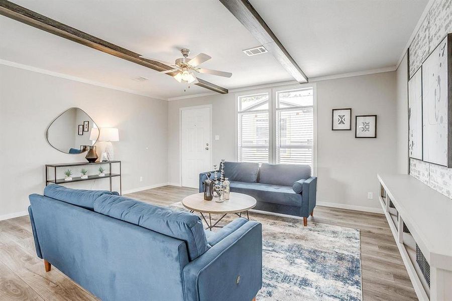 Living room with hardwood / wood-style flooring, ceiling fan, beam ceiling, and ornamental molding