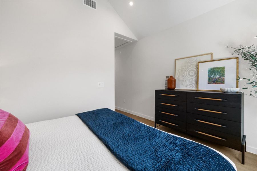 Bedroom with vaulted ceiling and baseboards