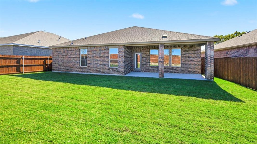 Rear view of property with brick siding, a patio, a fenced backyard, and a shingled roof Rear view of property with brick siding, a patio, a fenced backyard, and a shingled roof