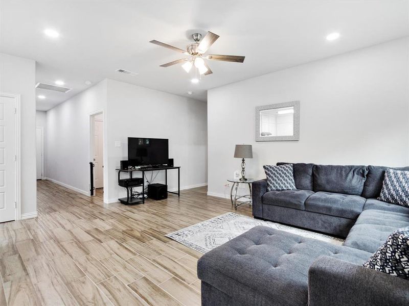 Open concept living area featuring wood-finish flooring, recessed lighting, and a ceiling fan
